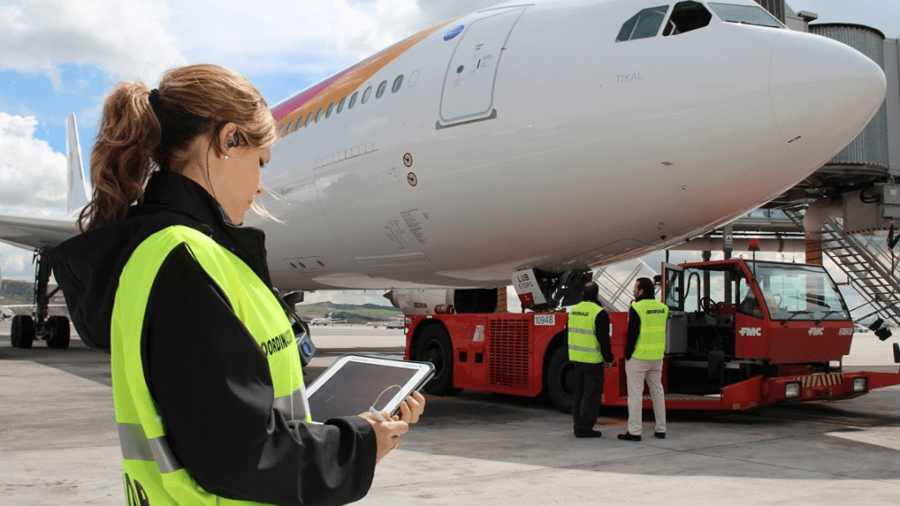 Una mujer, trabajando com auxiliar de rampa en un aeropuerto