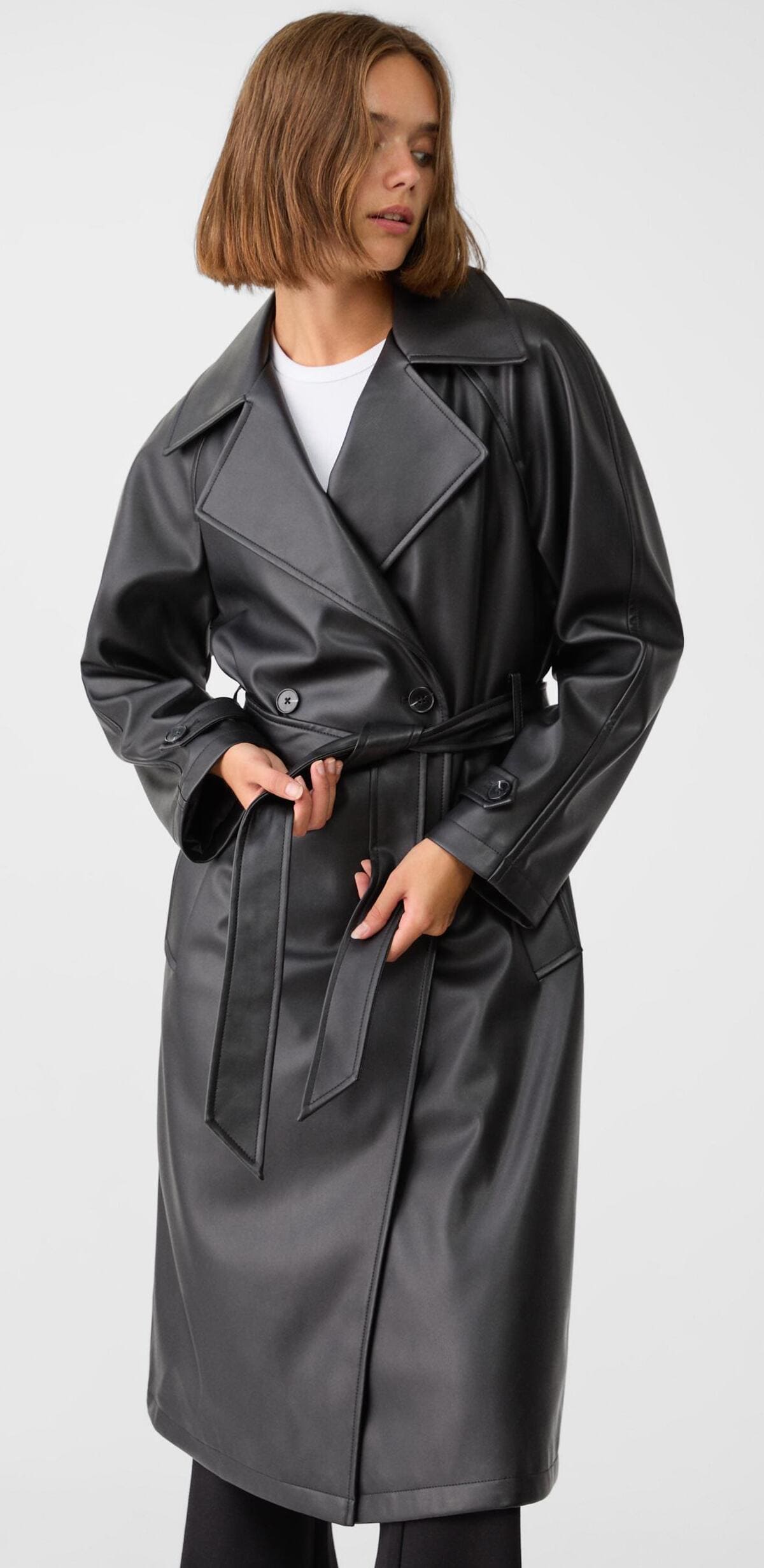 La nueva chaqueta trench larga de efecto piel en color negro de Stradivarius