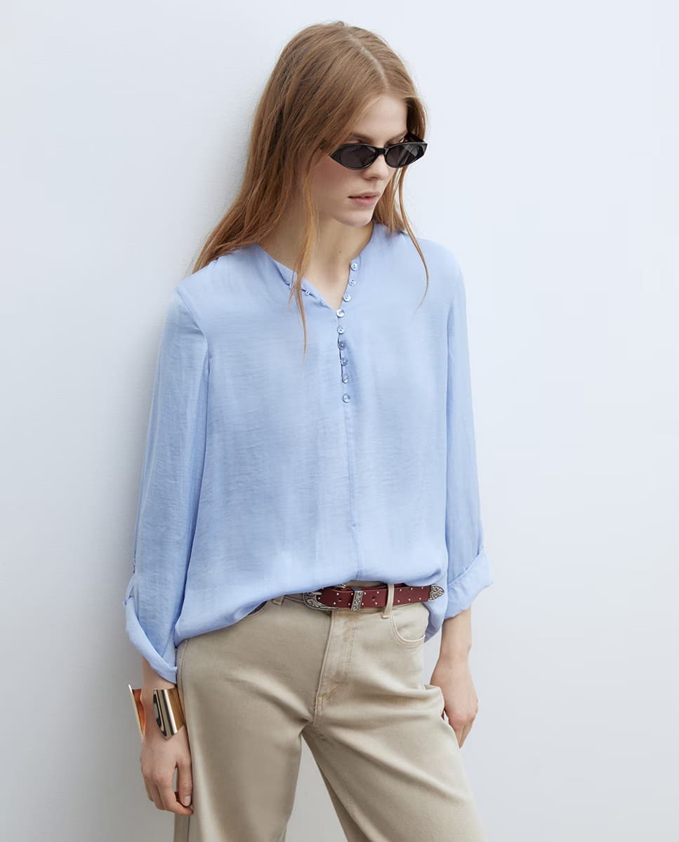 La blusa fluida con botones en color azul claro de Sfera en El Corte Inglés