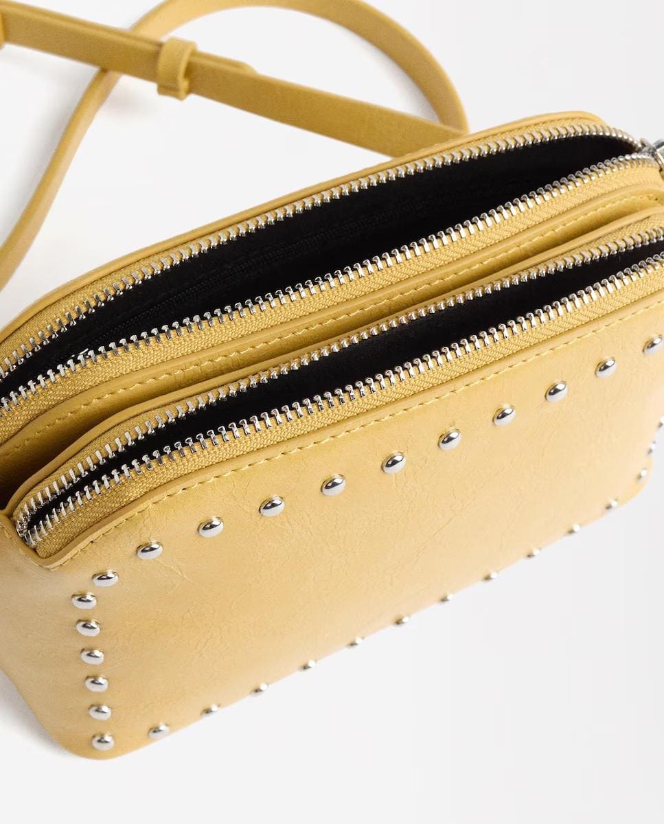 Bandolera con varios compartimentos y tachuelas