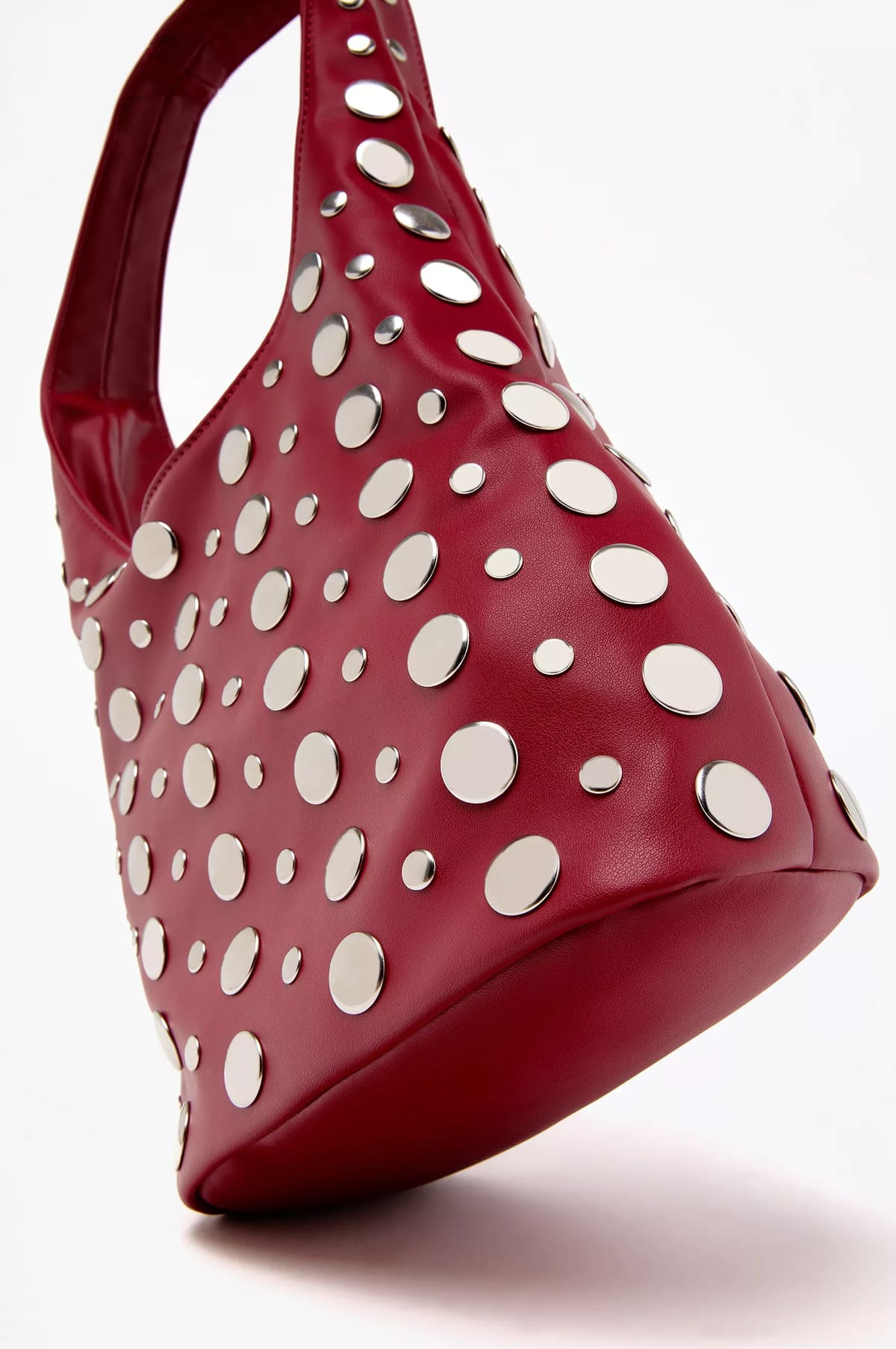 Bolso saco con detalle decorativo de tachas