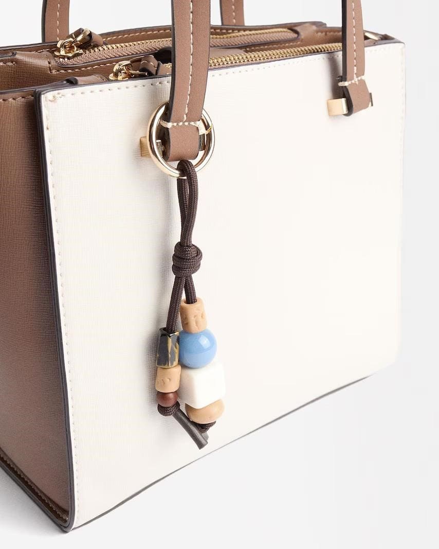 Bolso de mano estilo tote con varios compartimentos y llavero colgante