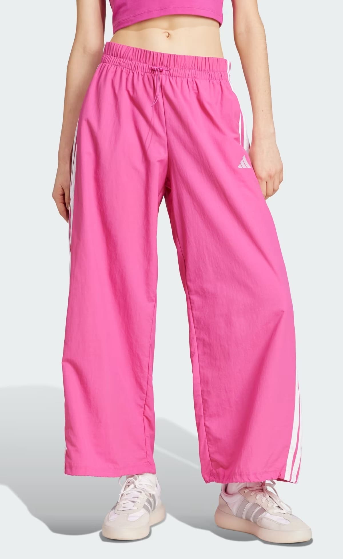 El nuevo pantalón Essentials Lifestyle Woven Parachute 3 bandas en color rosa de Adidas