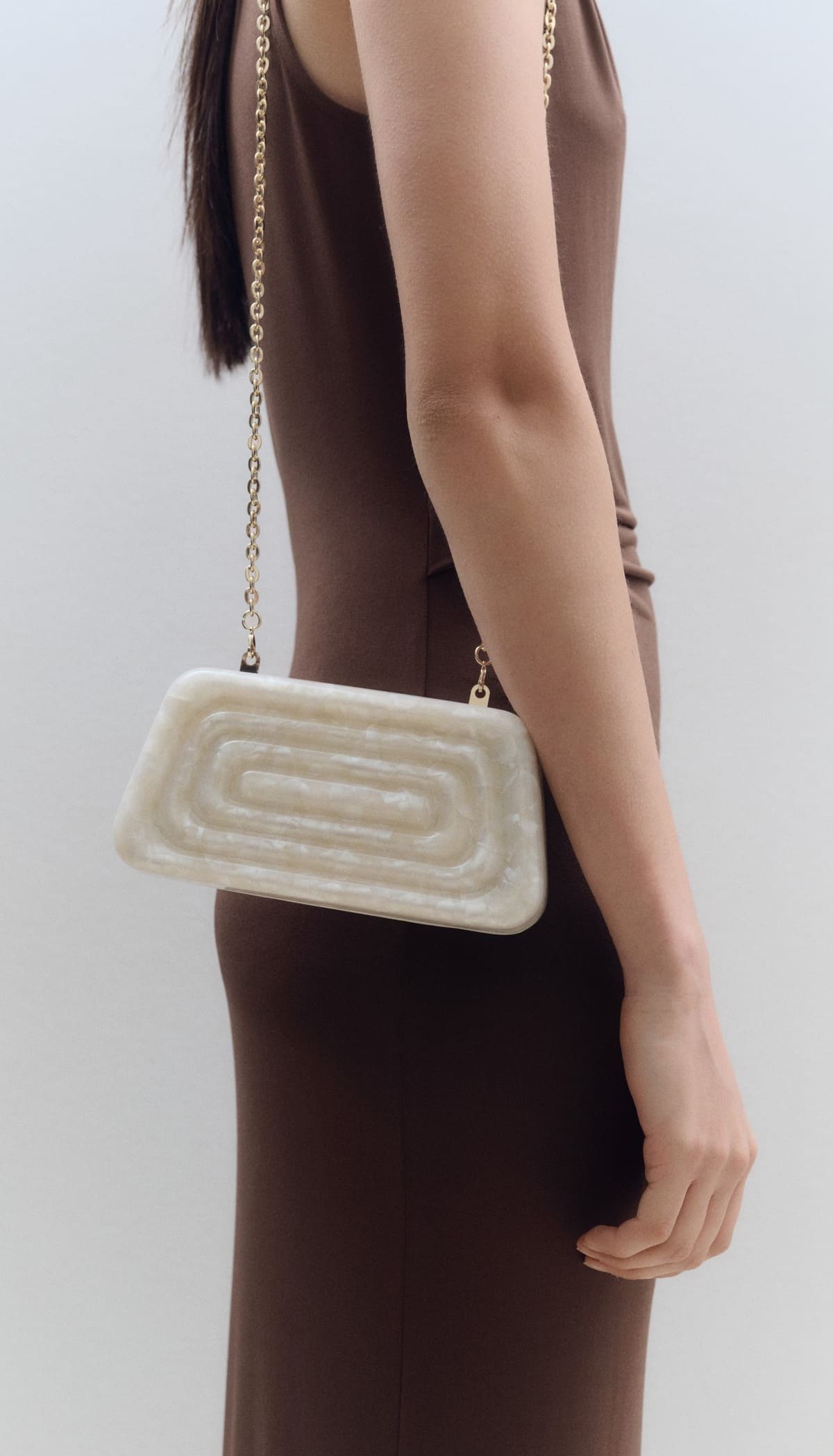 El bolso clutch efecto perlado en color blanco marfil de Mango