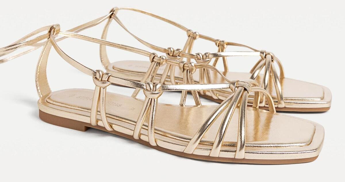 Las sandalias planas con tiras en color oro de Stradivarius