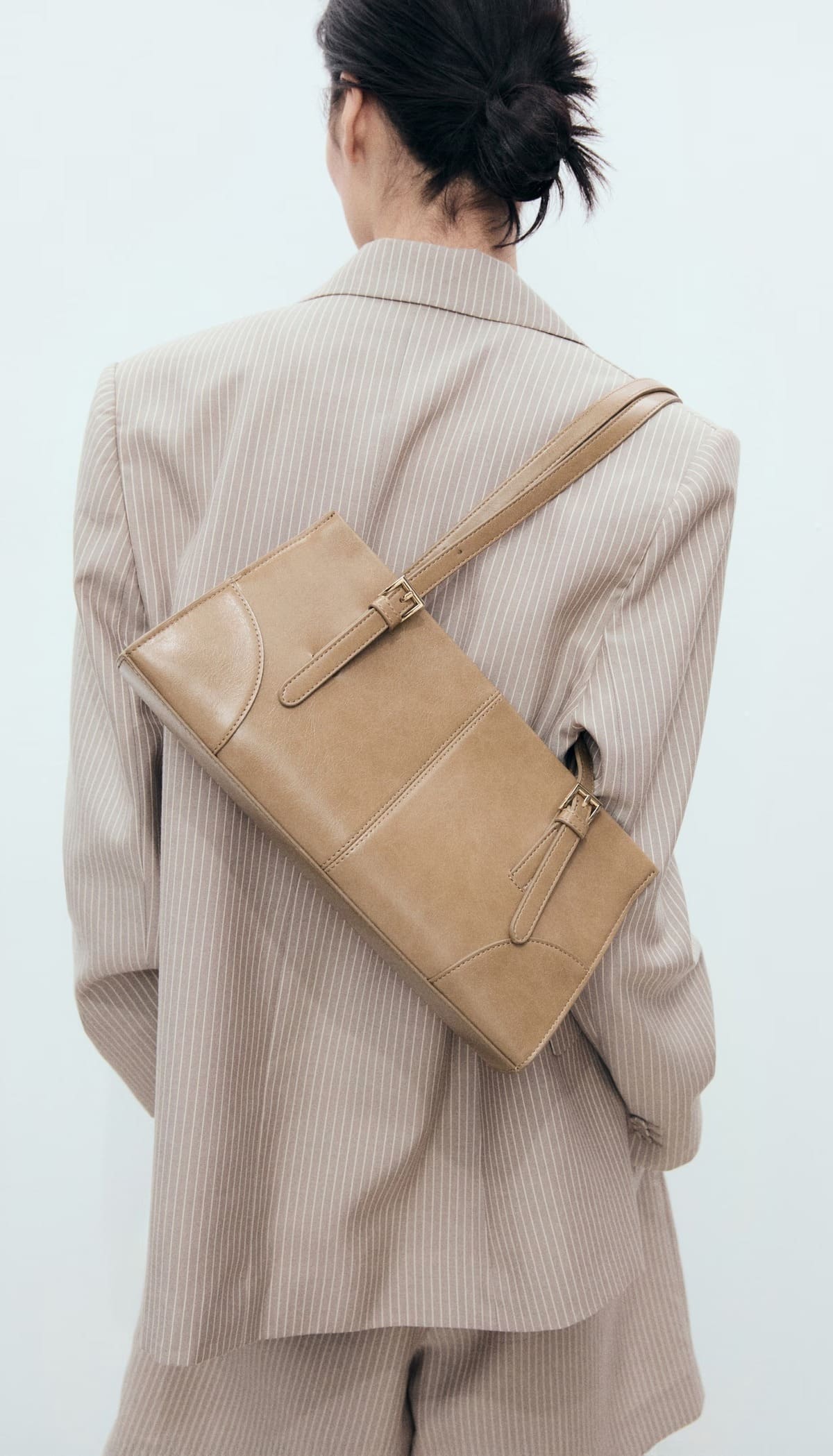 El bolso de hombro con hebillas en color marrón medio de Mango