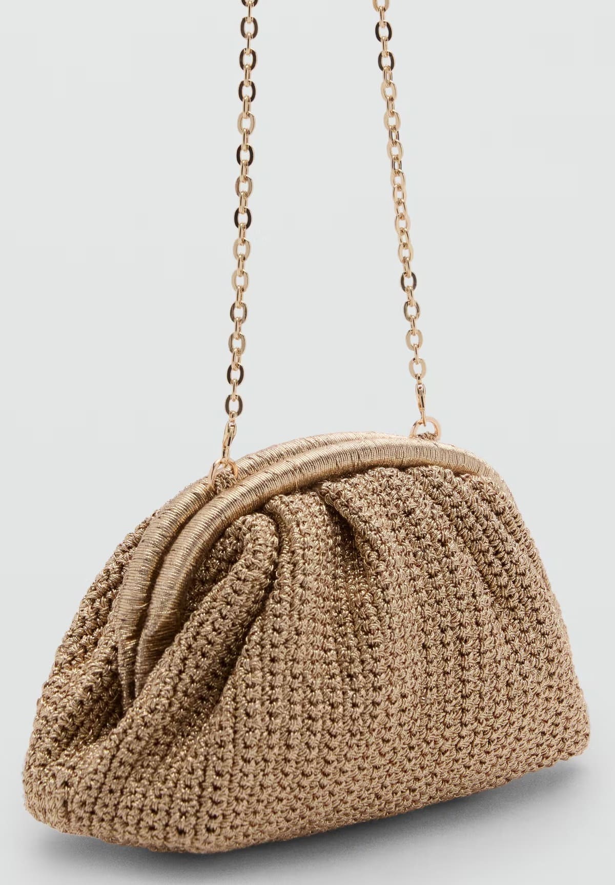 El bolso clutch con acabado de brillo en color oro de Mango
